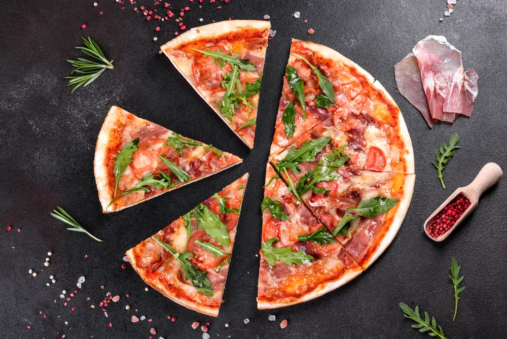 pizza con salsa de tomate, rúcula y otros aderezos