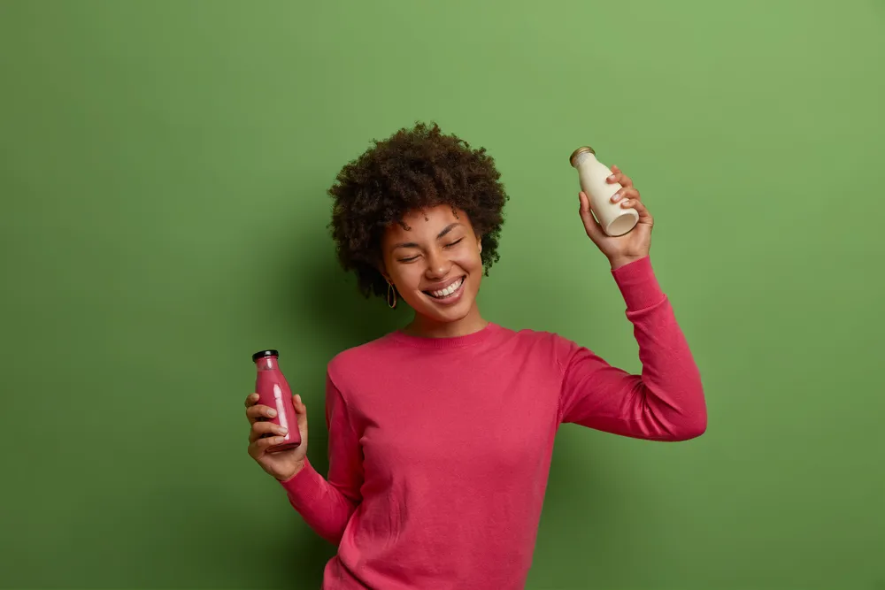 mujer sostiene coloridos batidos adelgazantes