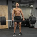 El hombre realiza entrenamiento FBW en el gimnasio.