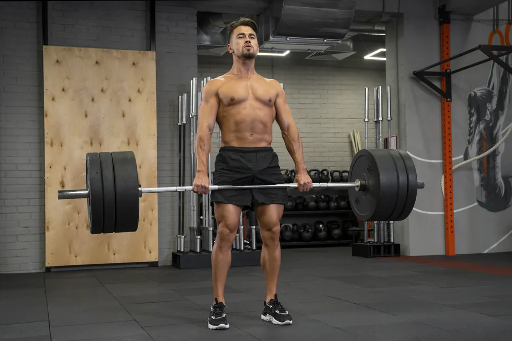 El hombre realiza entrenamiento FBW en el gimnasio.